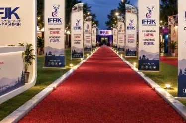 IFFJK-branded red carpet entrance with banner standees and lights leading to an archway at dusk.